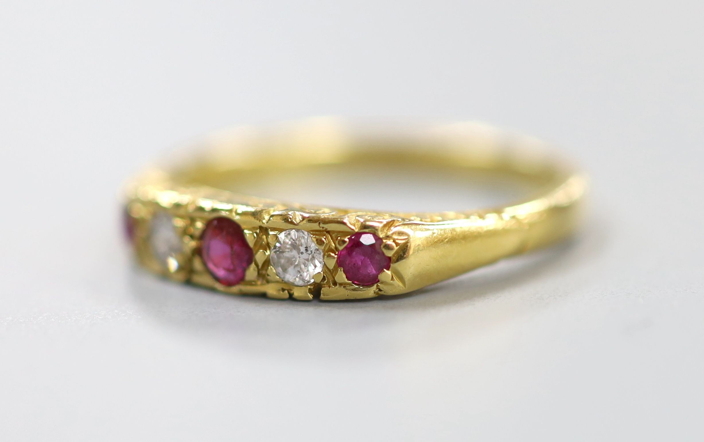A modern 18ct gold, two stone diamond and three stone ruby half hoop ring, size O, gross weight 3.8 grams.